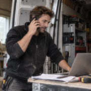 Ondernemer in zijn werkplaats die zijn vaste zakelijke nummer doorschakelt naar mobiel om bereikbaar te blijven.